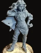 An unpainted resin miniature of Triste — a slender feminine figure in a flowing cloak and dress, long hair falling over one shoulder, standing on a textured round base